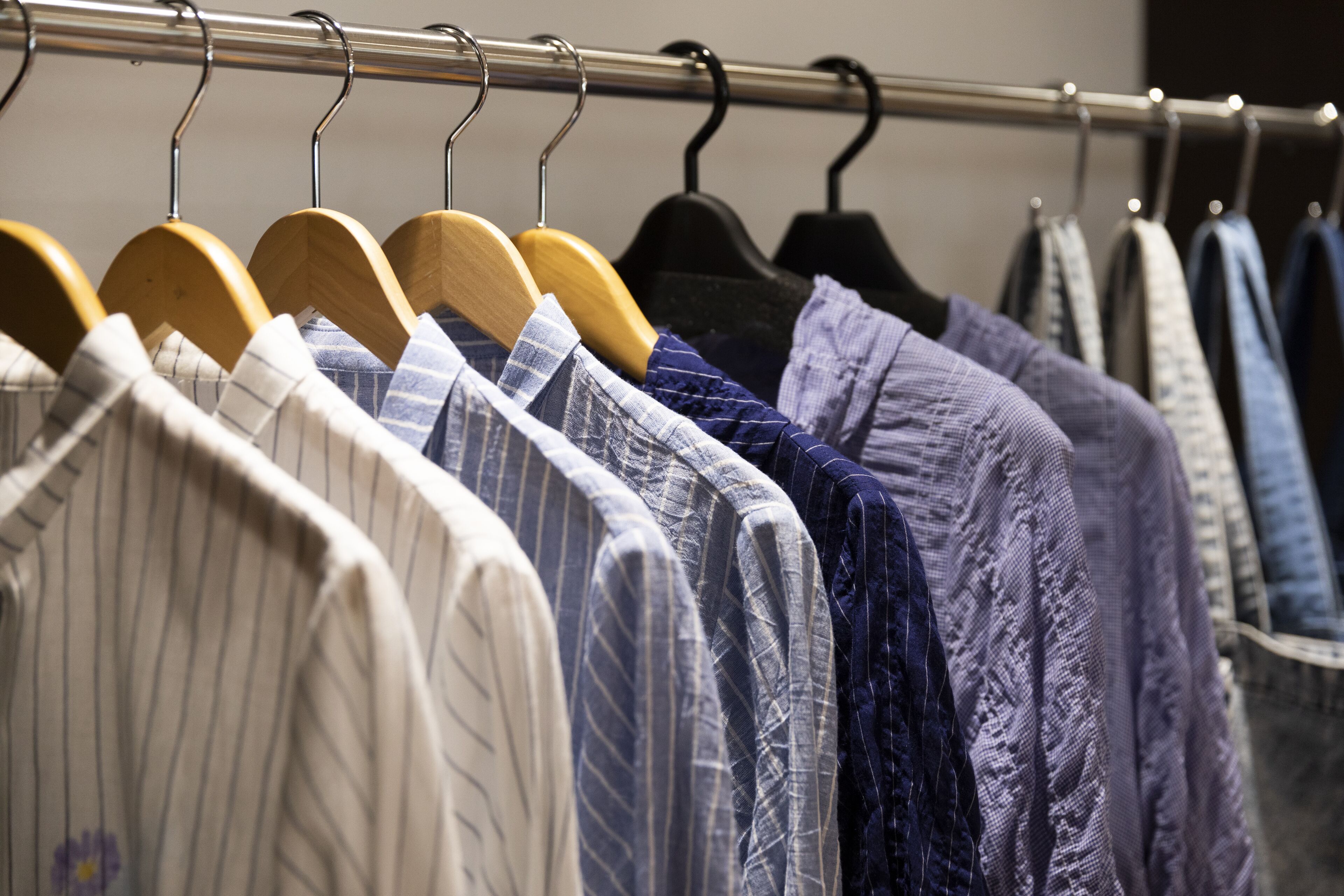 A clothing rack with various shirts and blouses.