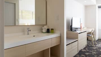 Un baño moderno con un espejo grande, un lavamanos y un mueble de tocador.