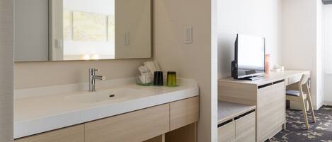 A modern bathroom with a large mirror, a sink, and a vanity.