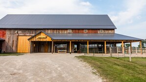 Un graner rústic amb un porxo cobert i un camí de terra.