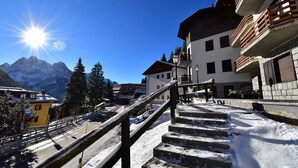 A snowy mountain town with a staircase leading to a building with balconies. - MIRA DOLO 022143-AT-347213 (Madonna di Campiglio)