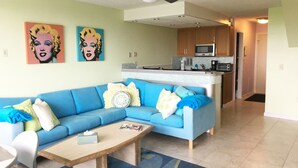 A living room with a blue sofa, a wooden coffee table, and a ceiling fan.