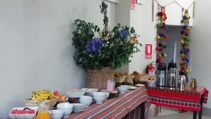 A buffet table with various food items, a large potted plant, and a fire extinguisher on the wall.