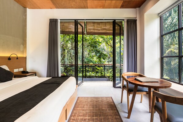 Svit Deluxe - utsikt mot trädgården | Minibar, värdeförvaringsskåp på rummet och skrivbord