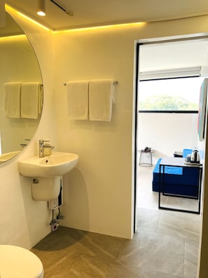 A modern bathroom with a sink, mirror, and two towels hanging on the wall. - Gomez House (Makati)