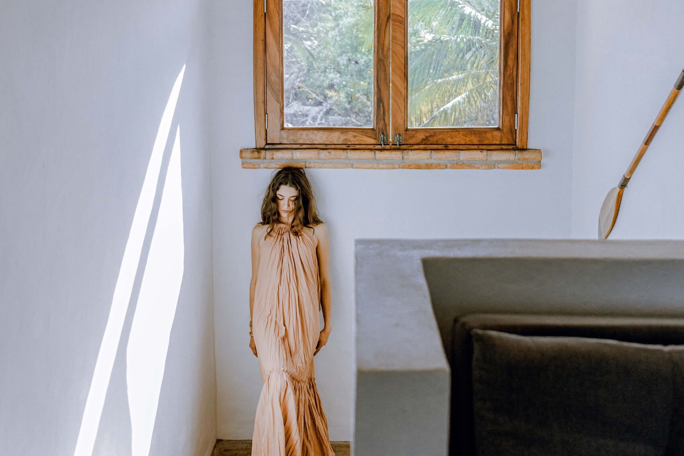 Una habitación con ventana, un armario de madera y una cama.