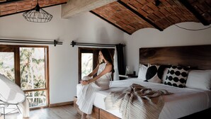 Una stanza con un letto, una sedia e un'ampia finestra.