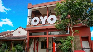 Ein zweistöckiges Gebäude mit einem gut sichtbaren „OYO“-Schild an der Fassade.