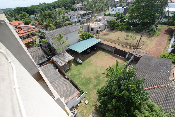 A residential area with multiple houses, a fenced yard, and a small building with a green roof.