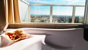 Habitación de hotel con un amplio ventanal y vistas a la ciudad.