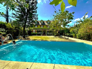 A swimming pool with a house in the background.