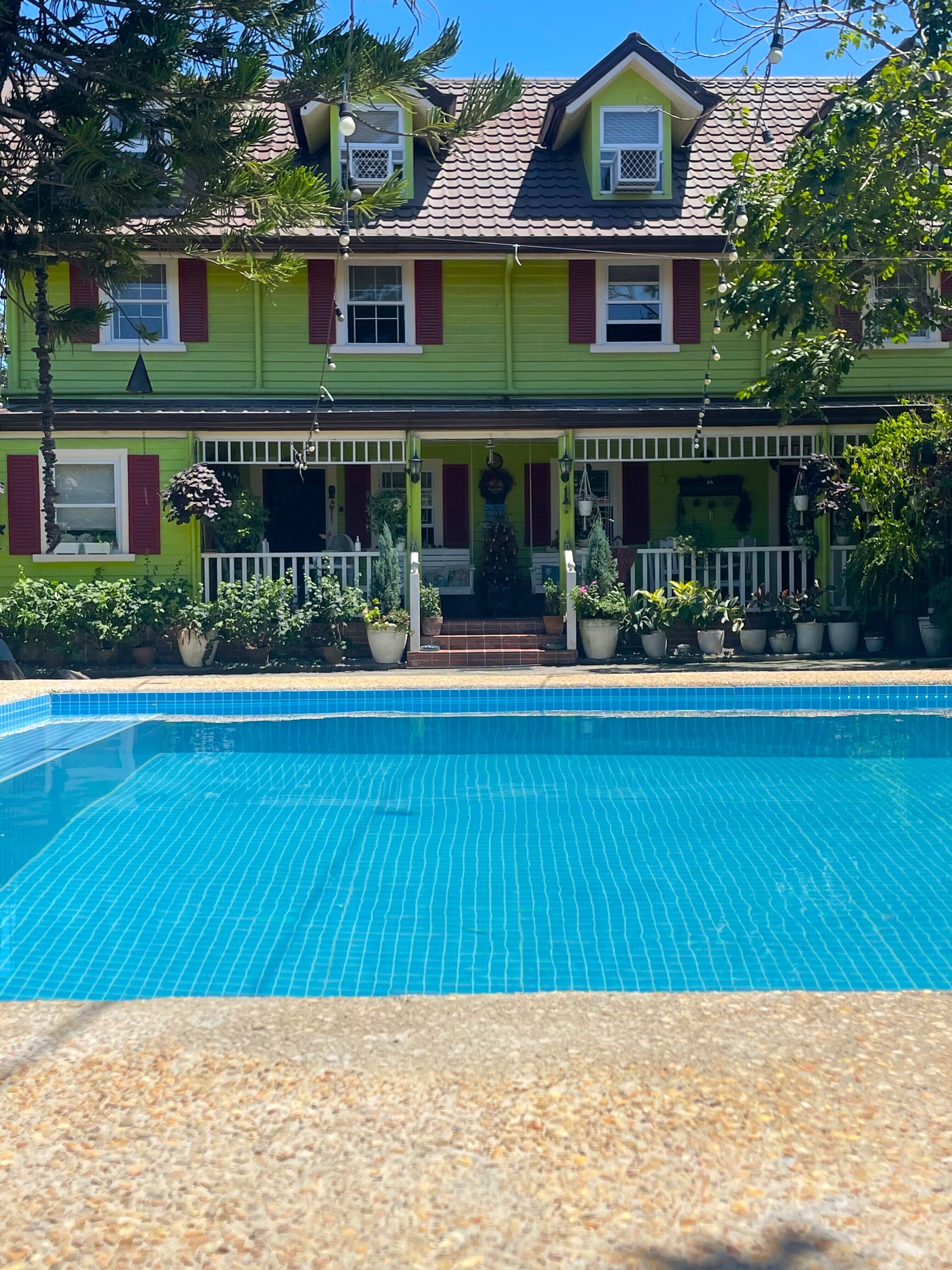 A two-story house with a swimming pool in front.