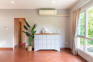 Relax in this serene room with a comfortable bed, a chest of drawers, and a large window with a view.