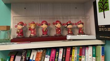 A bookshelf with various books and decorative figurines.