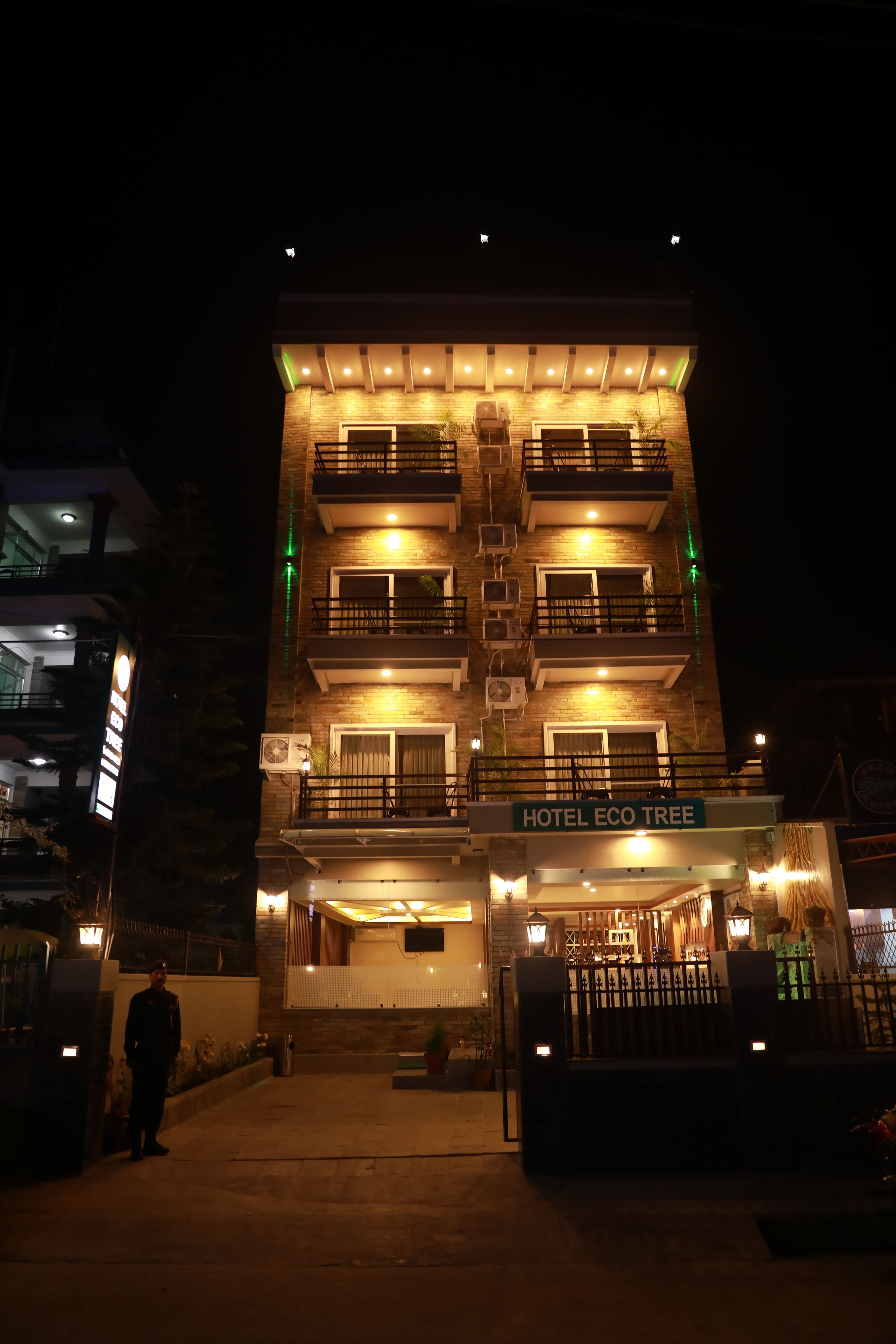 A multi-story building with a sign reading "HOTEL ECO TREE."