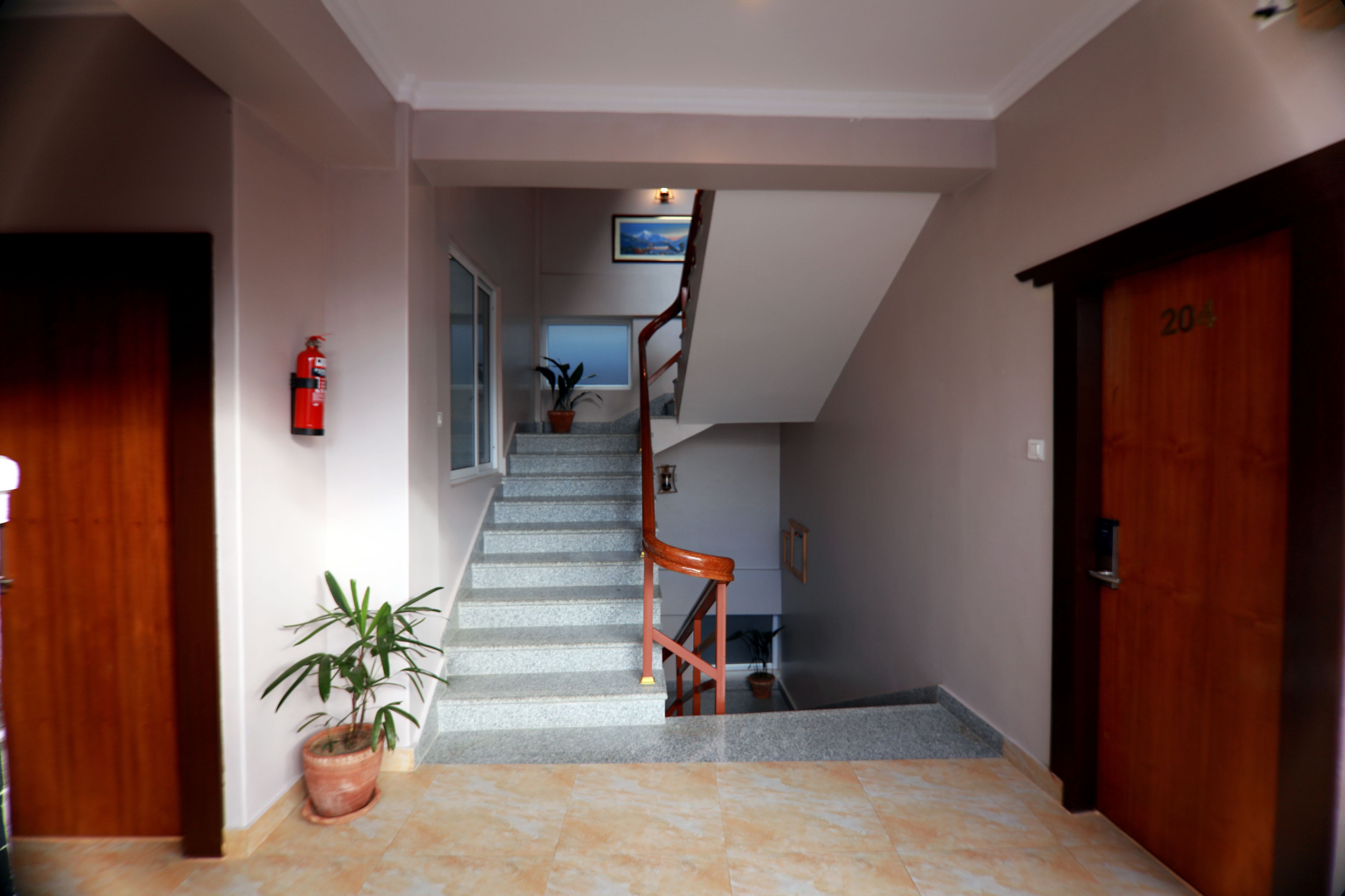 A staircase leading to a second floor, with a wooden door labeled "204" on the right.