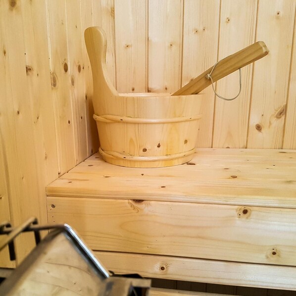 A wooden sauna with a wooden bucket and a wooden handle.