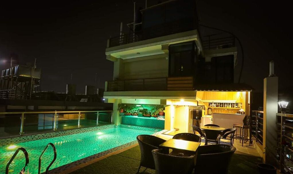 A rooftop pool area with a bar and seating.