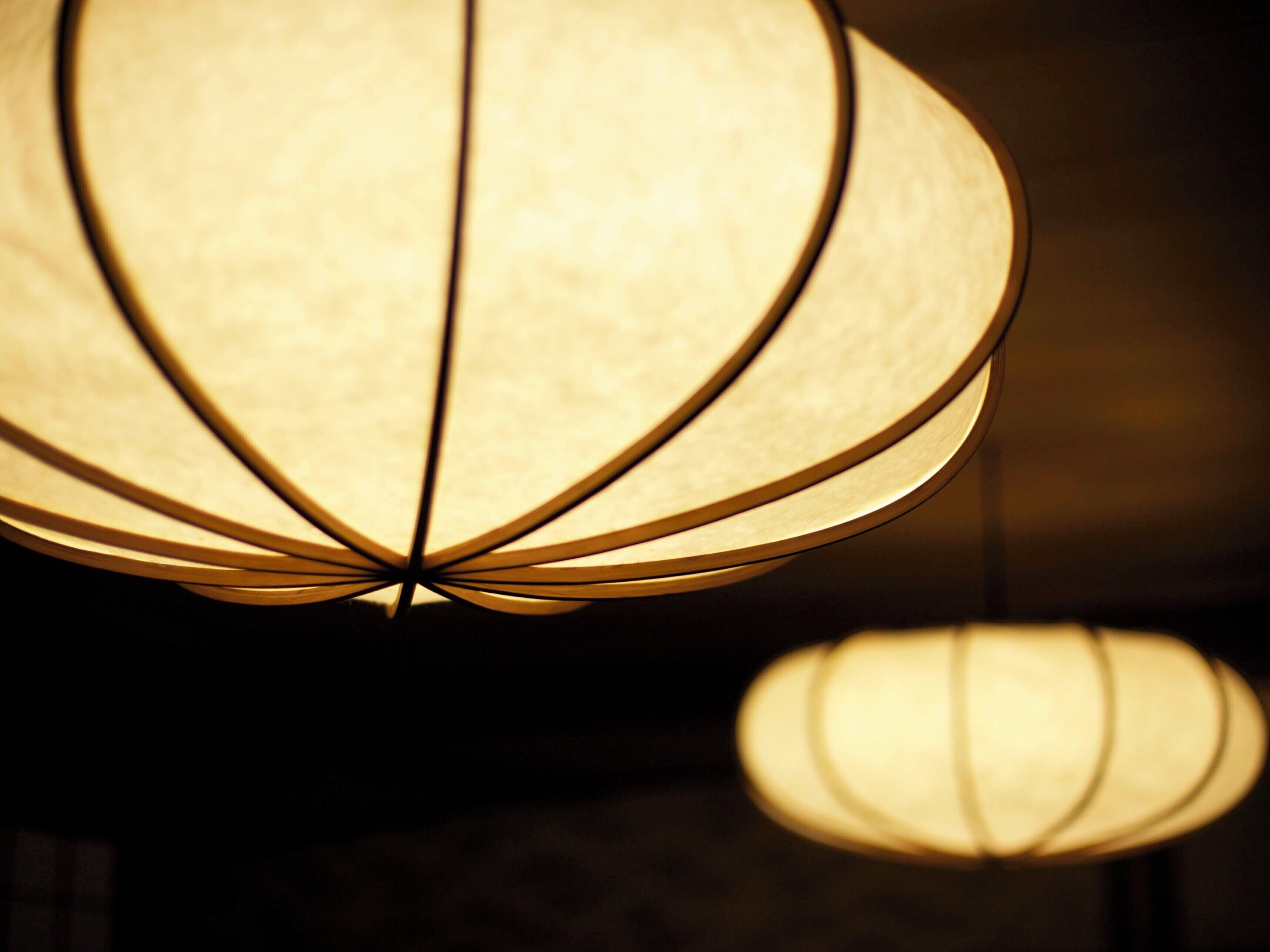 A close-up of a spherical hanging light fixture with a textured surface and a central rod.