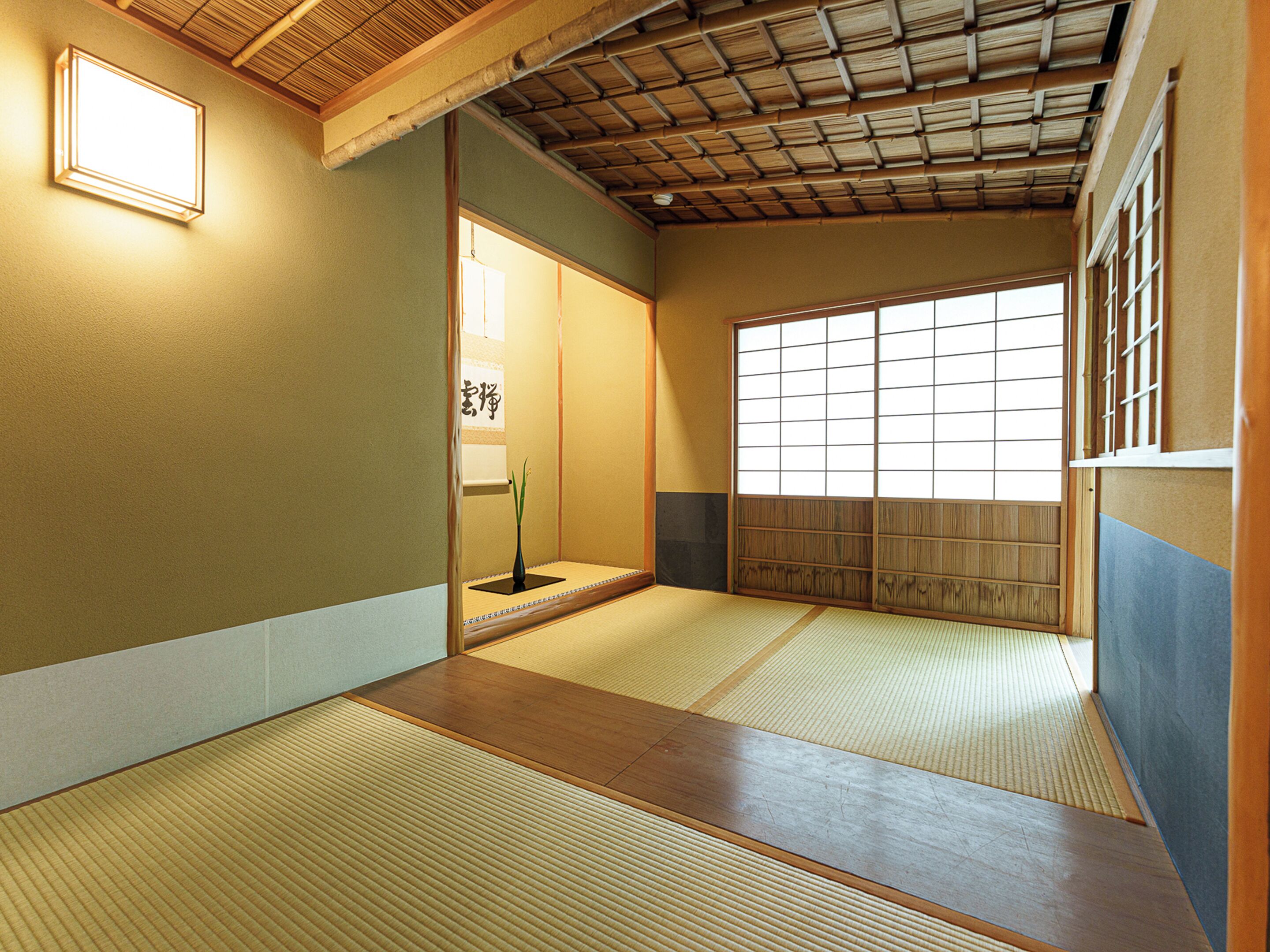 A traditional Japanese room with tatami flooring, sliding doors, and a shoji screen.