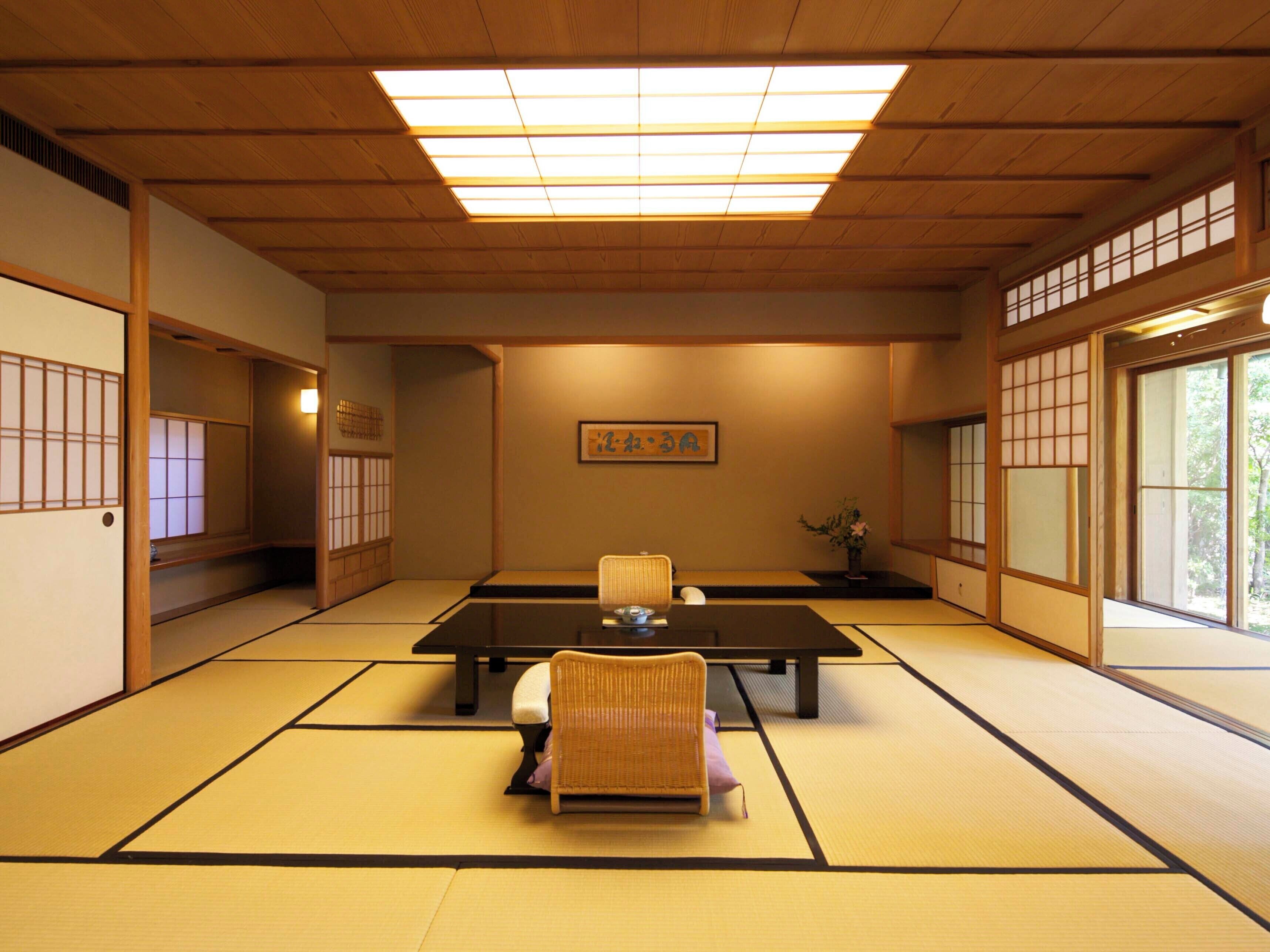 A traditional Japanese room with tatami flooring, a low table, and a chair.