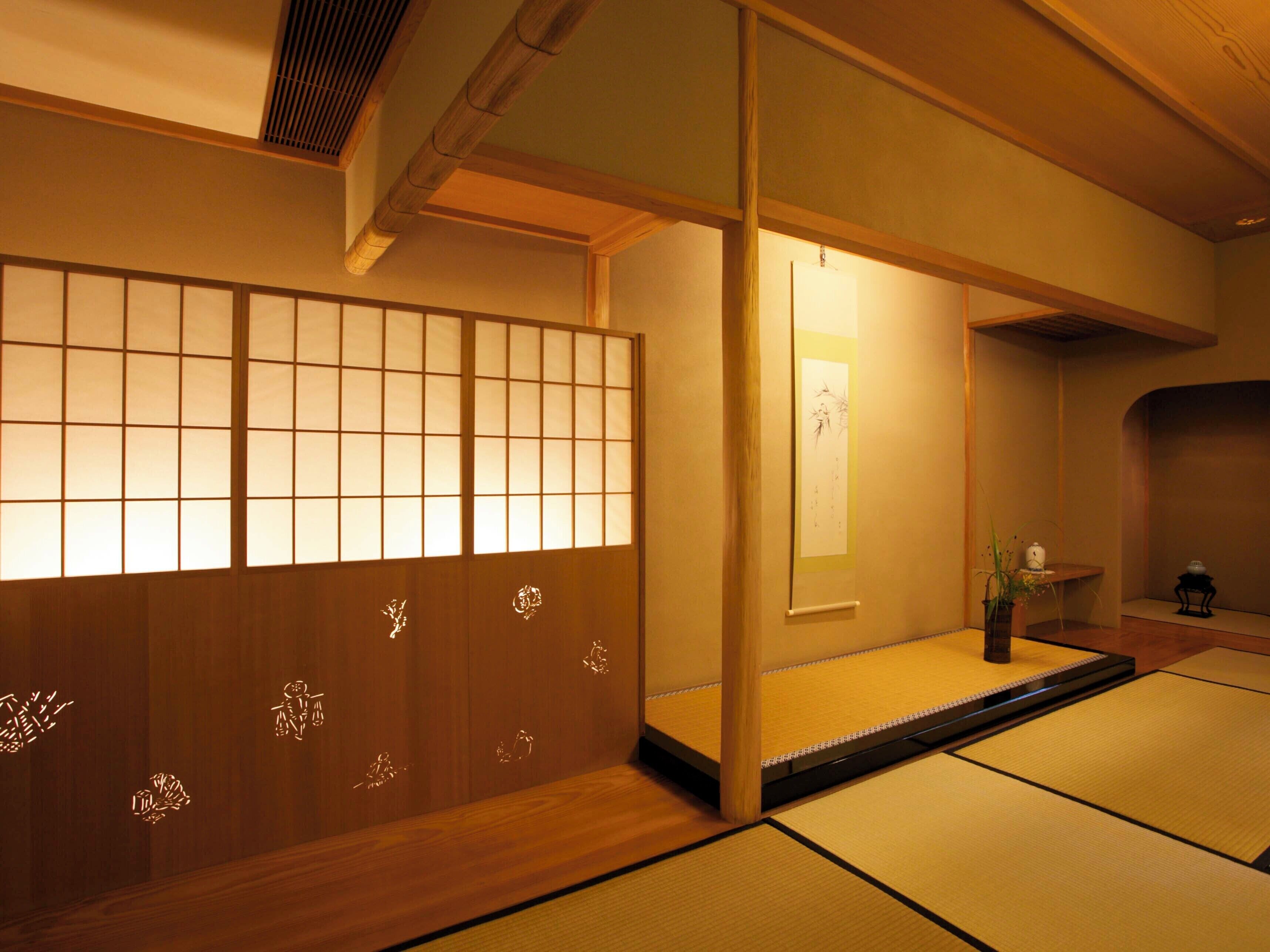 A traditional Japanese room with tatami flooring, a shoji screen, and a small table with a vase.