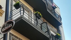 A multi-story building with balconies adorned with flower planters. - Il Borghese Tourist House (Gela)