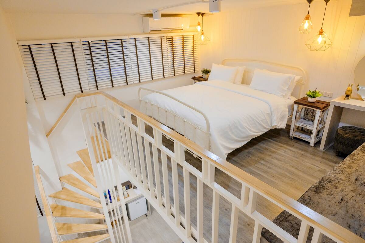 Ein Schlafzimmer mit einem Bett, einem Nachttisch und einem kleinen Schreibtisch mit Stuhl.