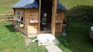 A wooden cabin with a sloped roof, a window, and a door.