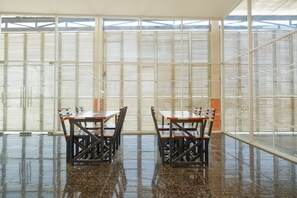 A spacious room with a polished floor and large windows with blinds. - Hotel O Unta Residence (Semarang)