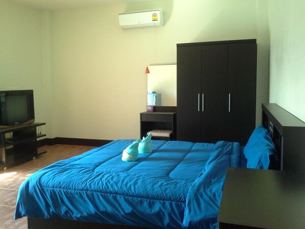 A bedroom with a bed, a wardrobe, a television, and a water dispenser. - Bansappuri (Lamphun)