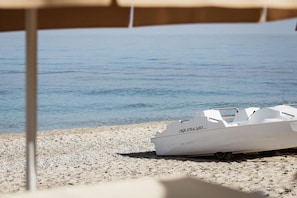 A boat named 'aquabLift' on a pebble beach with a clear view of the water. - Armacera Resort (Zambrone)