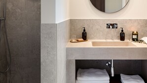 Un baño moderno con ducha, lavabo y espejo.