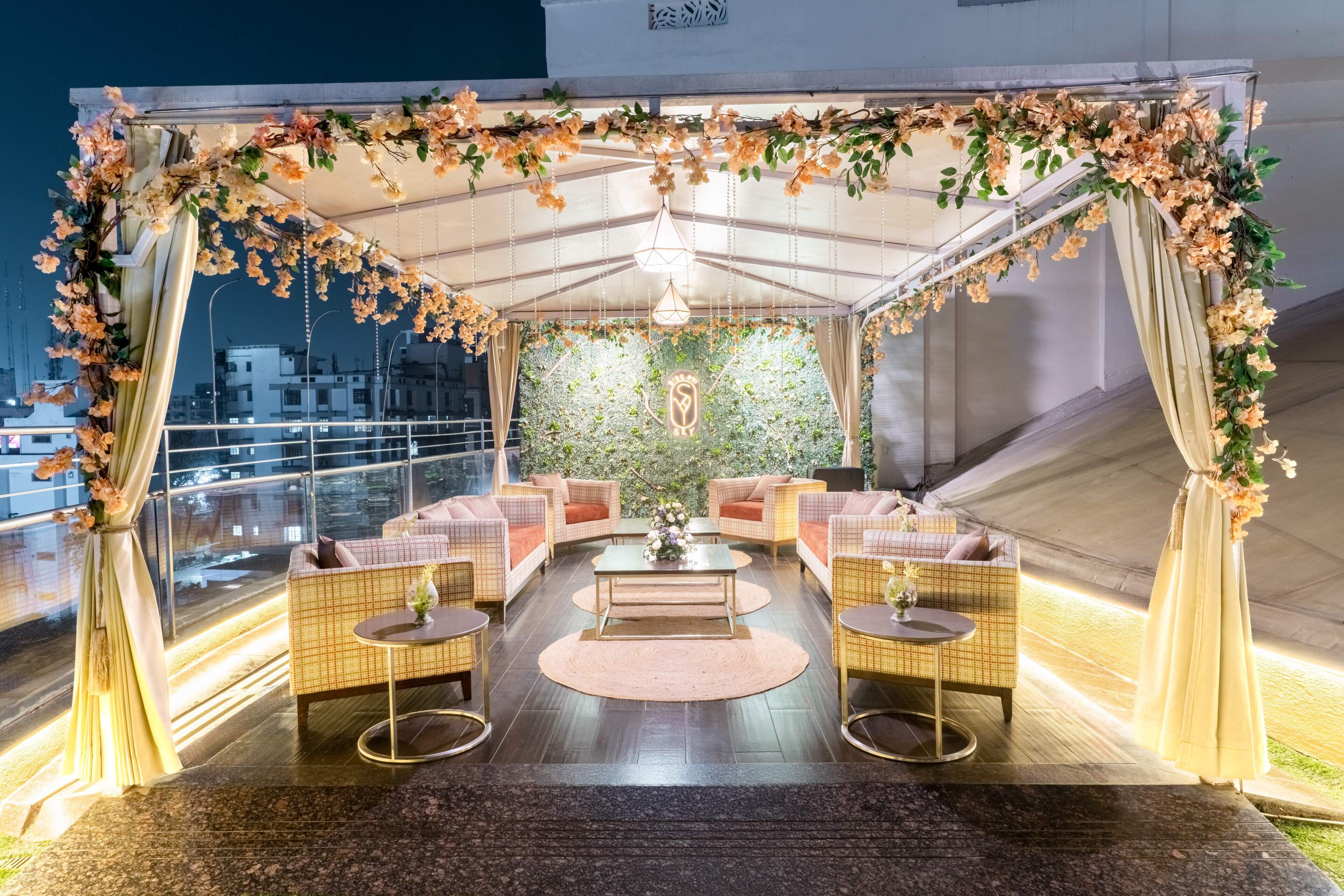 A rooftop terrace with a covered seating area, a decorative arch, and a view of the cityscape.