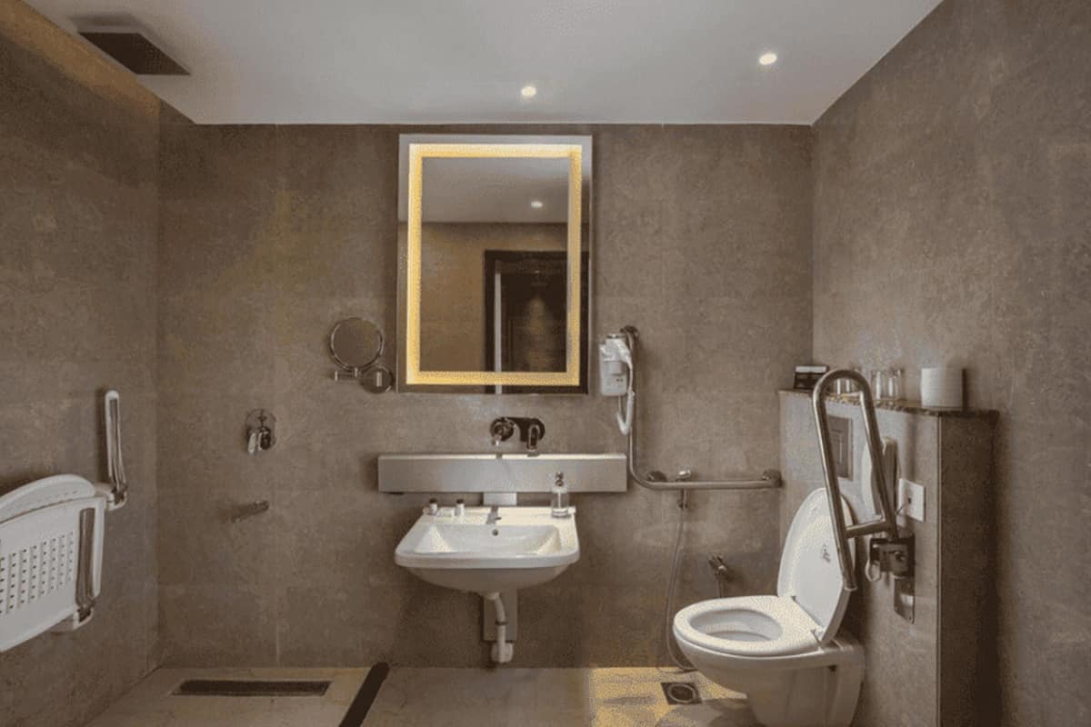 A modern bathroom with a sink, toilet, and mirror.
