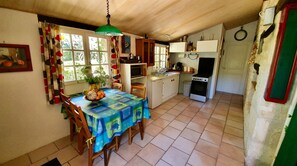 Cozy kitchen and dining area with a stove, microwave, and sink, perfect for preparing and enjoying meals.
