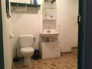 Ein kleines Badezimmer mit Toilette, Waschbecken und Stauraumschrank.