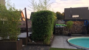 A backyard with a swimming pool, a brick patio, and a wooden deck. - Apartment in Haltern am See (Haltern am See)