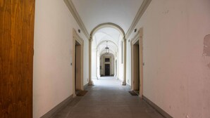 A corridor with arched ceilings and a tiled floor, leading to a door at the end. - Appartamento Santa Margherita (Bologna)