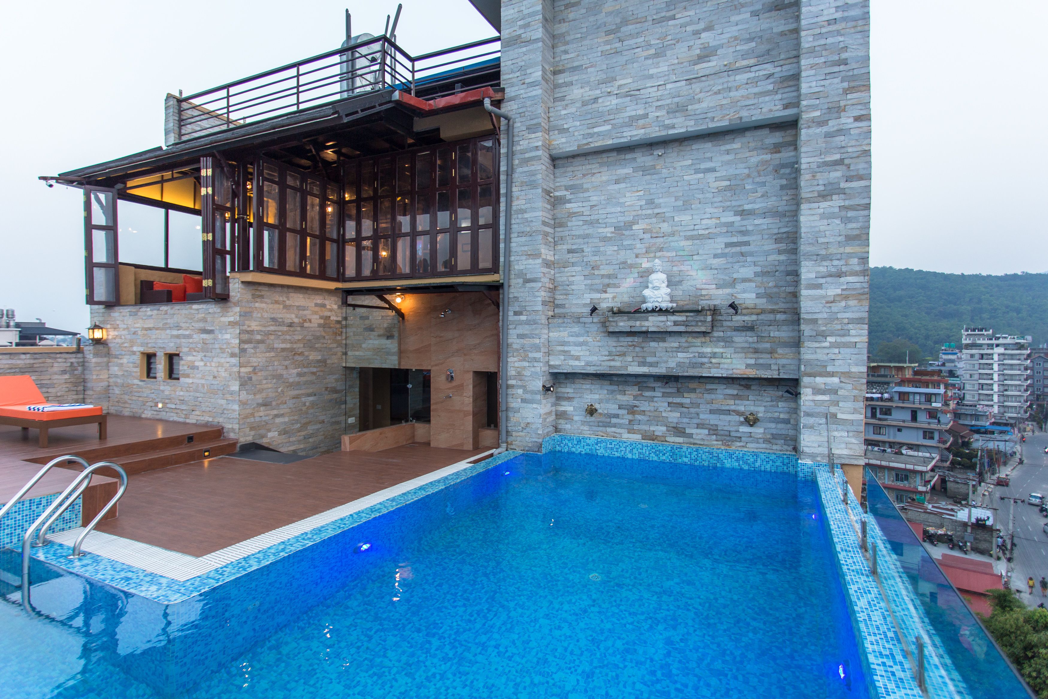 A modern building with a swimming pool, a balcony, and a view of the surrounding area.
