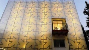 Un bâtiment doté d’une façade géométrique originale, caractérisée par un motif répétitif de lignes en zigzag.