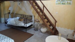 A bedroom with a bed, a wooden ladder, a white vase, and a painting of sheep on the wall. - Chambres d'hotes la Merais (Marsac-sur-Don)