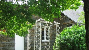 A stone building with a metal gazebo in front. - Chambres d'hotes la Merais (Marsac-sur-Don)
