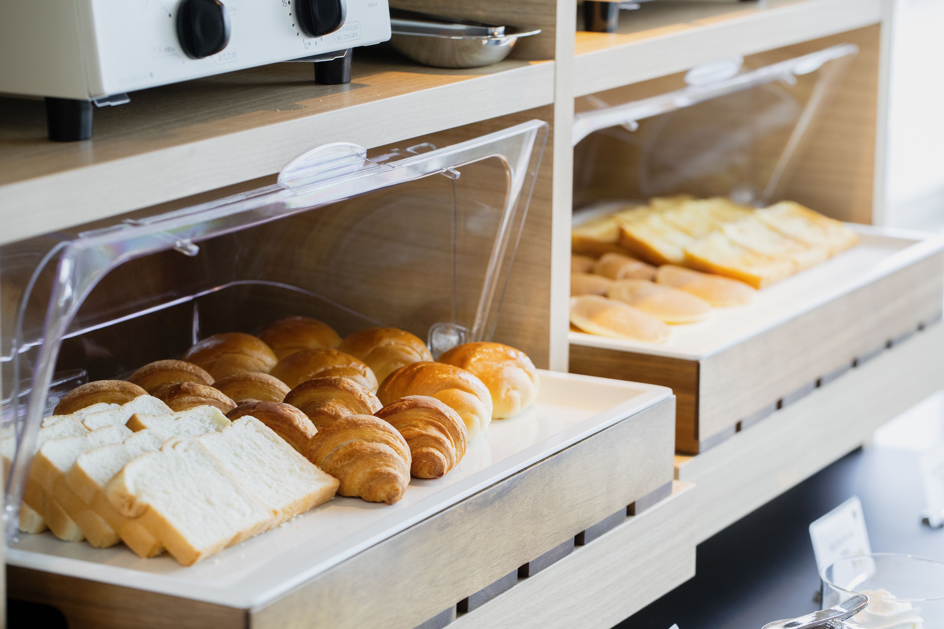A bakery display with various baked goods like bread and croissants.