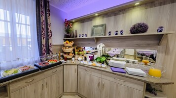 Cozinha bem equipada com serviço de buffet, incluindo diversos alimentos e bebidas.