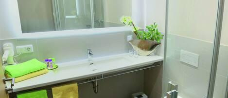 Ein modernes Badezimmer mit Duschkabine aus Glas, einem weißen Waschbecken und einer Toilette.