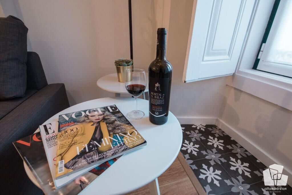 Een tijdschrift op een klein tafeltje, een fles wijn en een wijnglas.