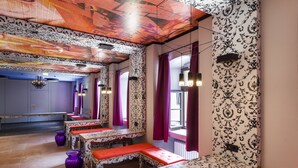 A room with patterned wallpaper, a chandelier, and a window with curtains. - Jugendherberge Würzburg - Hostel (Würzburg)