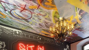 A vibrant lounge area with colorful seating and a neon sign. - Jugendherberge Würzburg - Hostel (Würzburg)