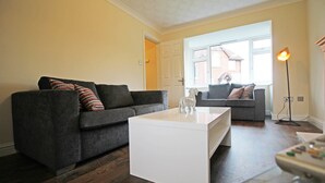 A modern living room with two grey sofas, a white coffee table, and a floor lamp. - 3 Bedroom Holiday Home With River Views (Frodsham)